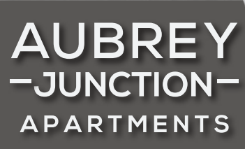 A sign that says Aubrey Junction Apartments.